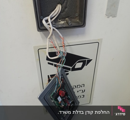 מערכת אינטרקום פתוחה עם חוטים חשופים על קיר